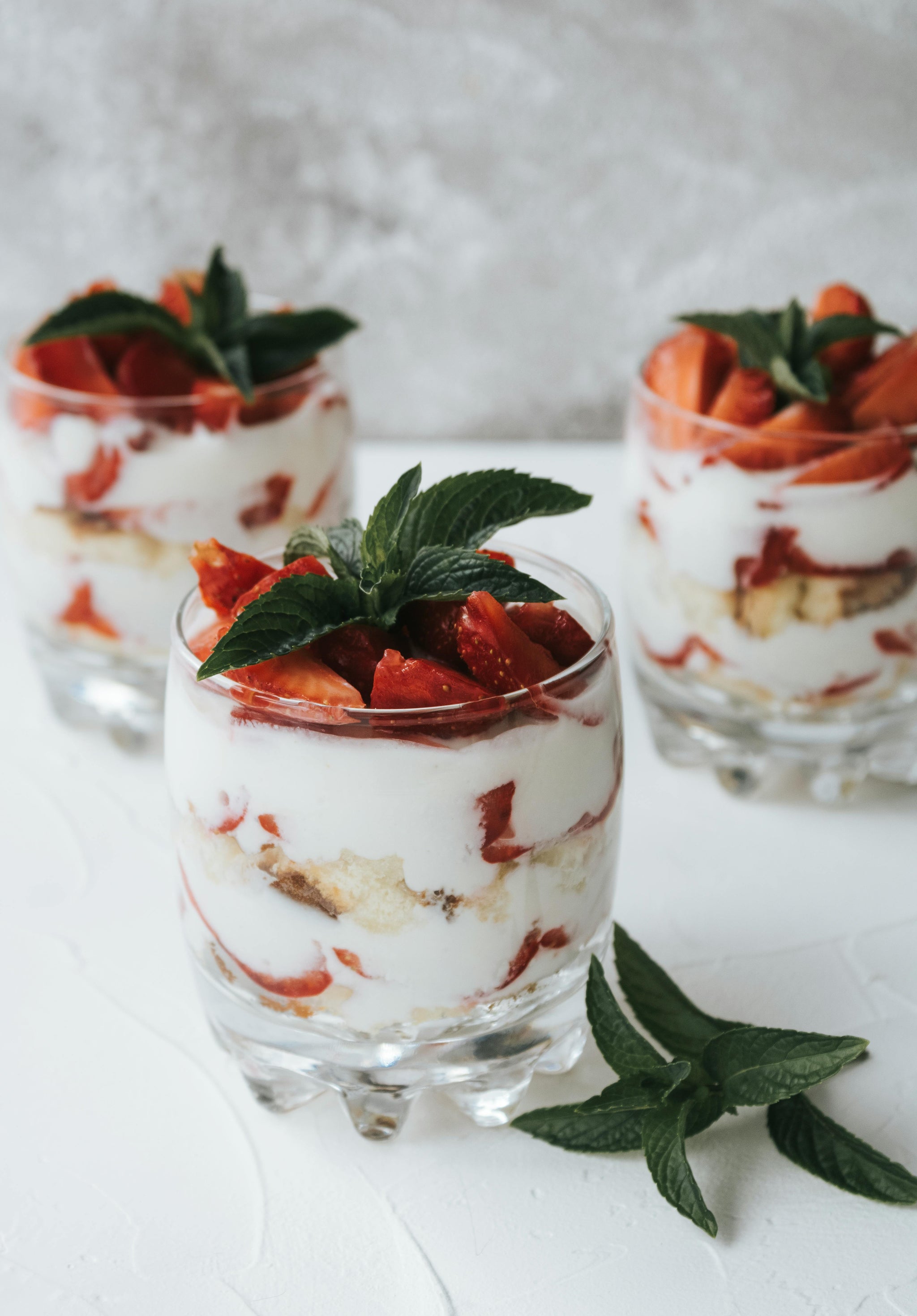 glass pots of fresh homemade yoghurts with strawberries made using the duronic electric yoghurt maker