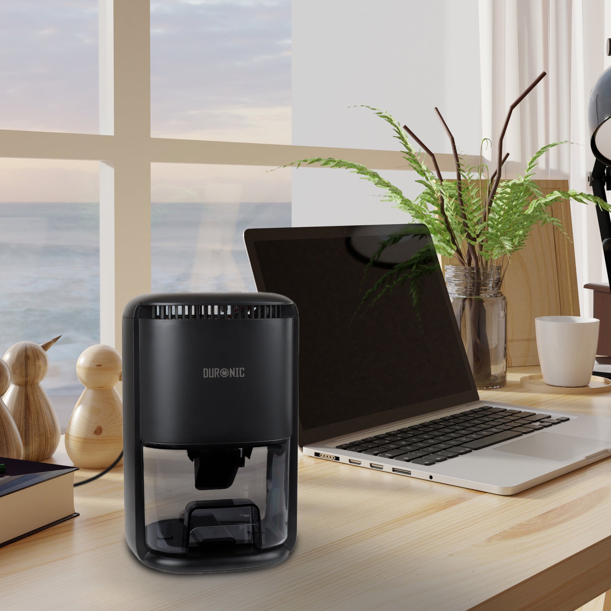 Duronic DH07 BK mini dehumidifier placed on desk alongside laptop