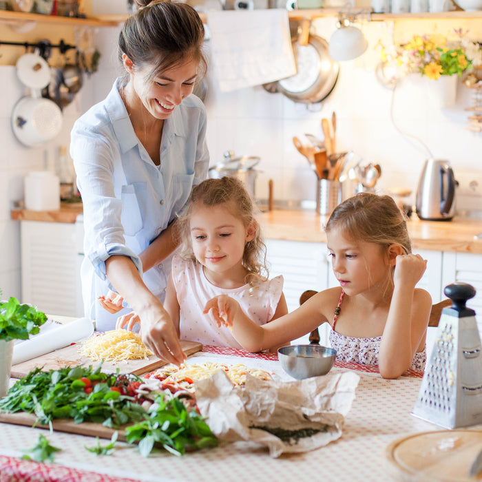 Happy family preparing food with cheese and vegetables to be cooked in the Duronic AF34 dual air fryer