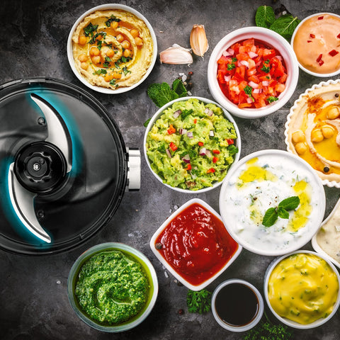 Duronic 2-in-1 Mini Food Processor and Chopper next to bowls of hummus, guacamole, salsa, pesto, and various dipping sauces.