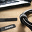 Duronic Cable Ties organizing thick black cords neatly on a wooden desk near a laptop.
