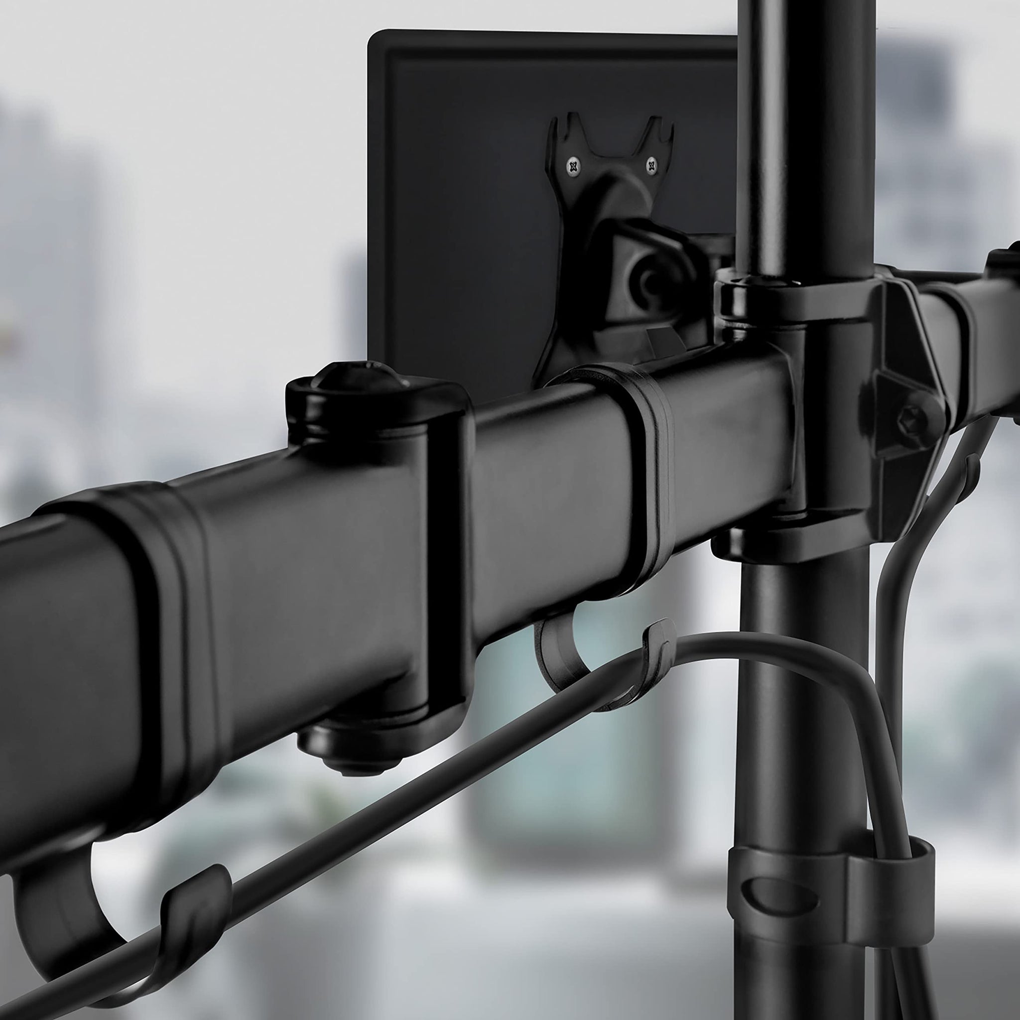 Duronic Dual Monitor Arm Stand Desk Mount featuring integrated cable management clips attached to a vertical desk pole.