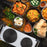 Duronic Electric Hot Plate HP2 WE sitting beside an assortment of Indian curry dishes.