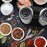Duronic Electric Salt and Pepper Grinder Set on a black tray surrounded by colorful gourmet spices.