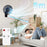 Duronic FN12 BK Wall Mounted Fan blowing airflow toward a man using a remote control from 5m away.