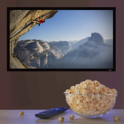 Duronic Projector Screen w a bowl of popcorn and a remote control on a table before a wall-mounted TV.