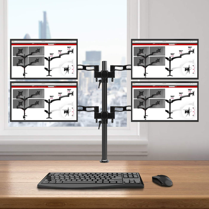 Duronic Quad Monitor Arm Stand holding four screens in a 2x2 grid over a wooden desk.