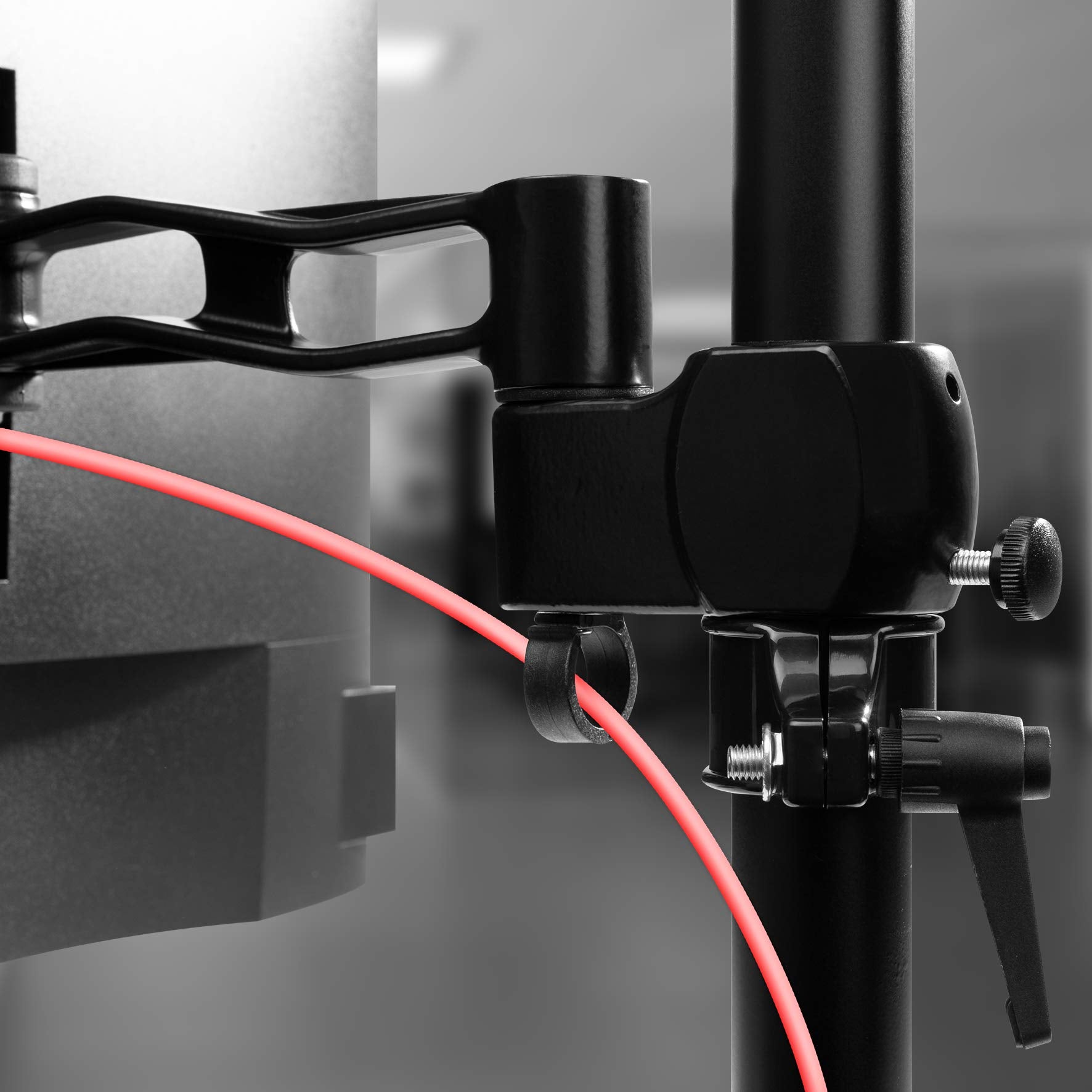 Duronic Quad Monitor Arm Stand with integrated cable management clip routing a bright red cord.