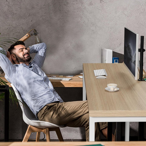 Duronic Single Monitor Arm with a man relaxes at a light wood desk