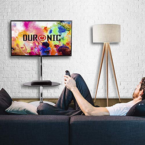 Duronic TV Stand floor mounted on a sleek chrome floor stand next to a wooden tripod lamp.