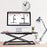 Duronic Sit-Stand Desk with a monitor, clock, and desk lamp.