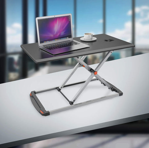 Duronic Sit-Stand Desk featuring a height-adjustable silver X-frame base, shown holding a laptop and a cup of coffee.