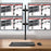 Duronic Computer Quad Monitor Arms holding four screens in a 2x2 layout over a wooden desk.
