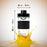 Duronic Blender Spare Bottle with a 18cm height and 8cm width shown splashing into orange juice.