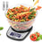 Duronic Digital Kitchen Scale featuring a large clear bowl filled with tri-color fusilli pasta, a backlit LCD display showing 680g, and two included AAA batteries.