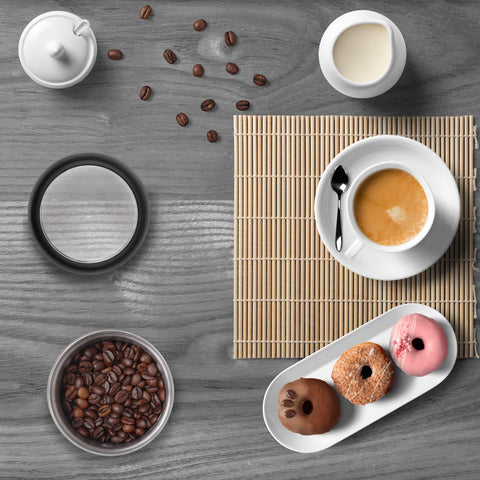 Duronic Electric Coffee Grinder with a cup, three donuts, loose coffee beans, and cream.