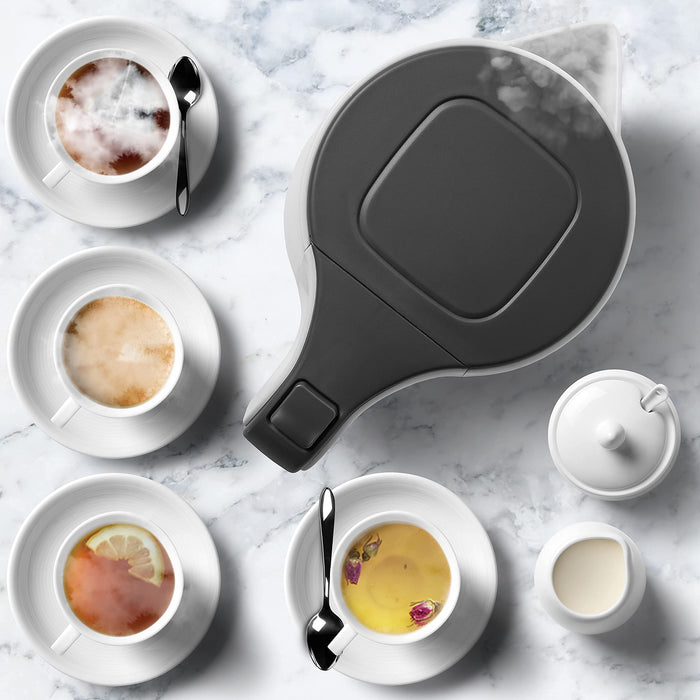 Duronic Electric Kettle surrounded by four assorted tea cups on marble.