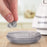 Duronic Fabric Shaver with a hand empties gray lint