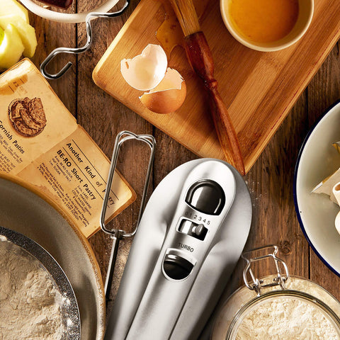 Duronic HM4 SR electric hand mixer on aesthetic medieval table mixing ingredients for pastry