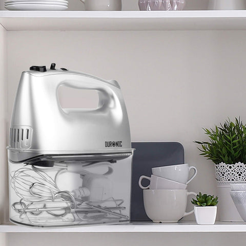 Duronic HM4 SR silver hand mixer with attachments in storage case placed on aesthetic shelf alongside other kitchen items