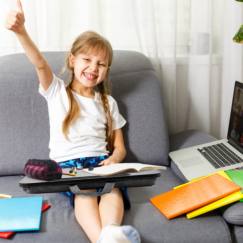 Duronic Laptop Tray with smiling young girl using a portable lap desk on a couch with school supplies nearby
