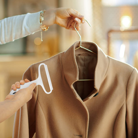 Duronic Lint Shaver on a tan wool coat on hanger.