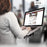 Duronic Monitor Arm Laptop Attachment with woman typing on a laptop mounted on a DM35 ergonomic desk arm stand.