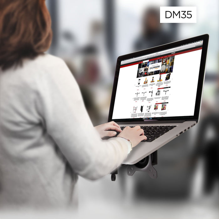 Duronic Monitor Arm Laptop Attachment with woman typing on a laptop mounted on a DM35 ergonomic desk arm stand.