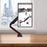 Duronic Monitor Arm Stand clamped to a desk in a modern office.