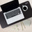 Duronic Monitor Stand Riser with top view of a silver laptop, coffee cup, and desk mat on a workspace surface.
