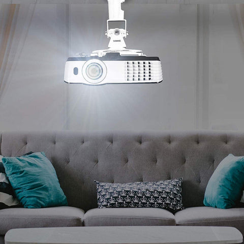 Duronic Projector Mount Ceiling-mounted projector casting light in a living room above a grey sofa with blue pillows.