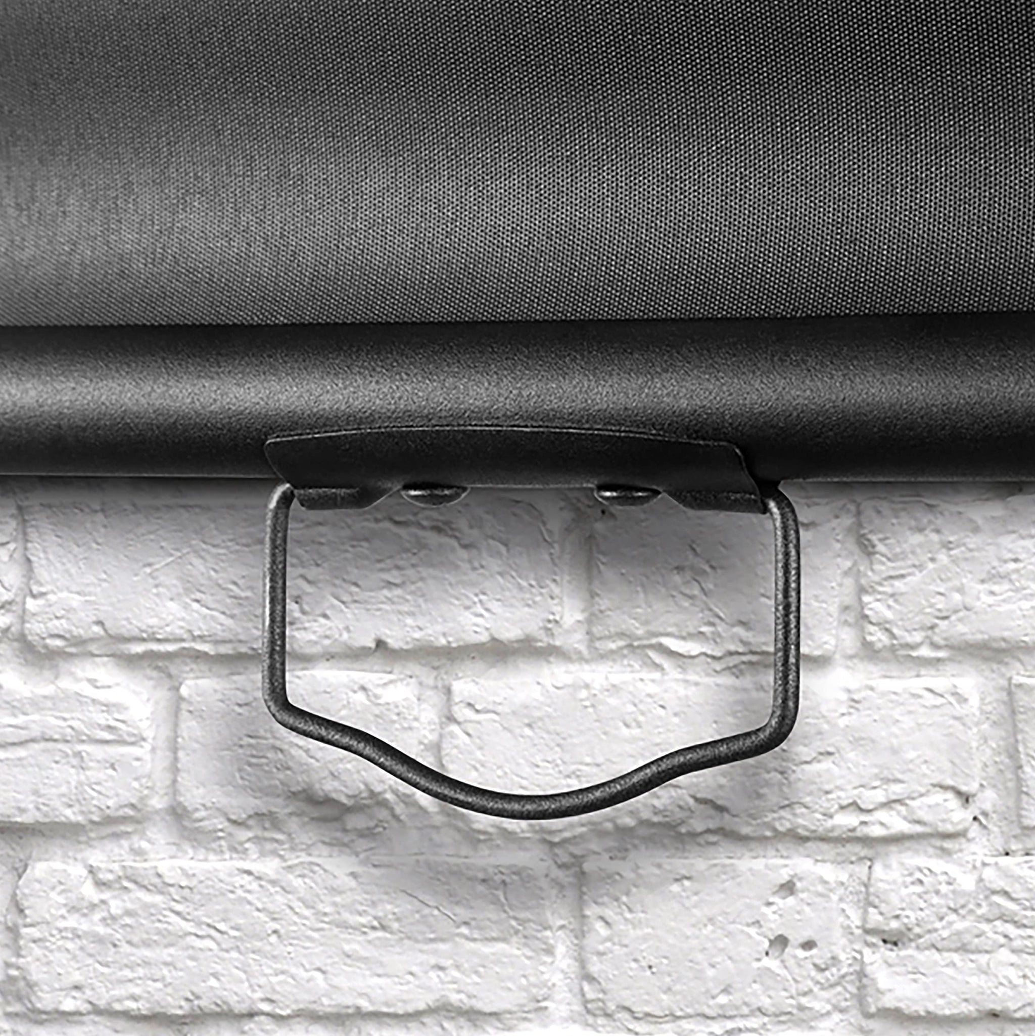 Duronic Projector Screen pull down projector screen handle against white brick wall.