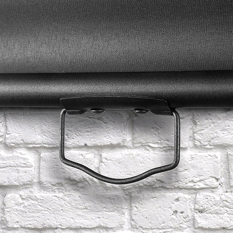 Duronic Projector Screen pull down projector screen handle against white brick wall.