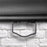 Duronic Projector Screen showing with close up view of black pull down handle on a screen against white brick wall.