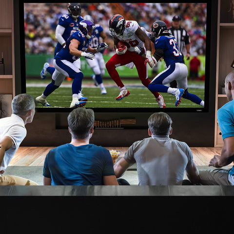 Duronic Projector Screen with Four friends watching a football game on a large television screen in a living room.