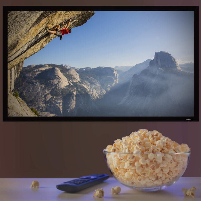 Duronic Projector Screen with Large glass bowl of popcorn and a remote control in front of a TV.