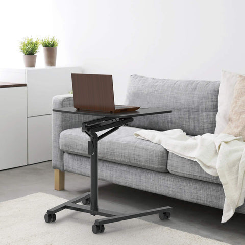 Duronic Projector Stand with a laptop on top, positioned next to a gray sofa.
