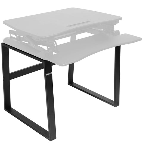 Duronic Sit-Stand Desk Frame supporting a faded standing desk converter on a white background. 