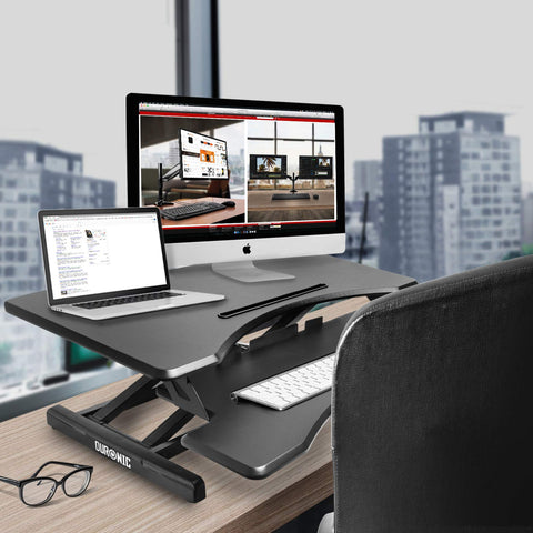 Duronic Sit-Stand Desk with a laptop, monitor, and keyboard on top.