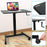 Duronic Sit-Stand Desk with black tabletop, laptop, and hand crank mechanism.