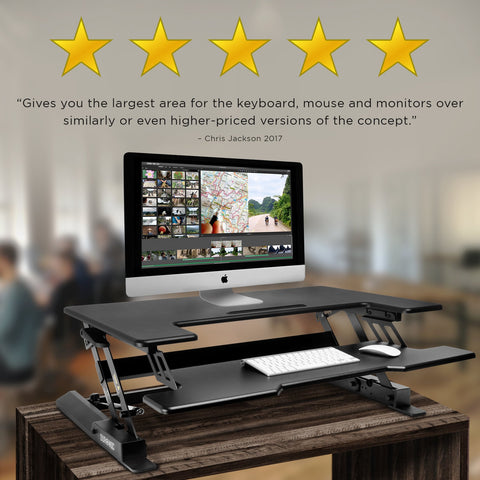 Duronic Sit-Stand Desk with dual tiers holding an Apple Mac computer, keyboard, and mouse.