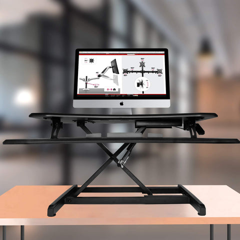 Duronic Sit-Stand Desk with two tiers supporting an Apple iMac computer monitor.