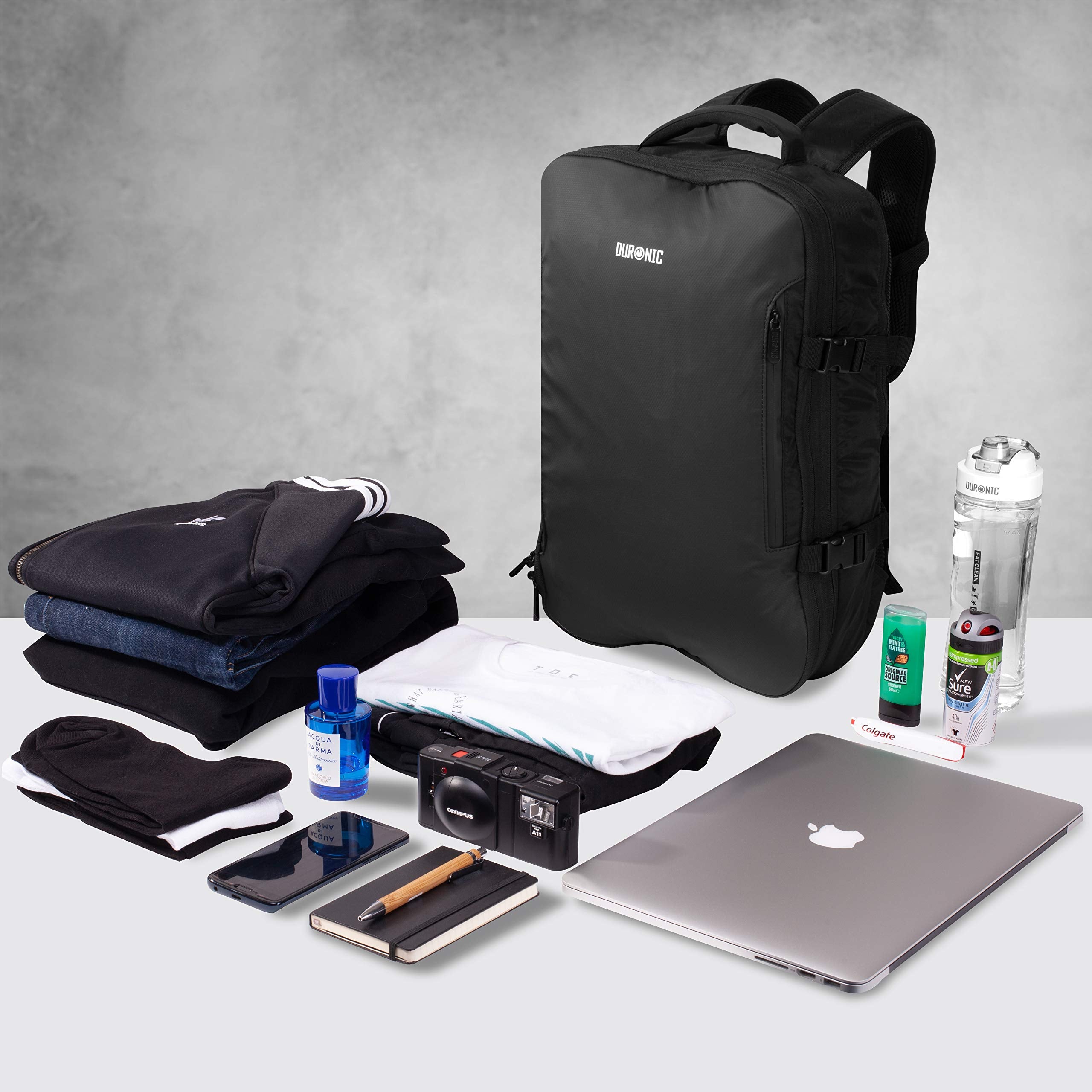 Duronic Travel Cabin Bags surrounded by neatly arranged clothing, a laptop, camera, and toiletries.